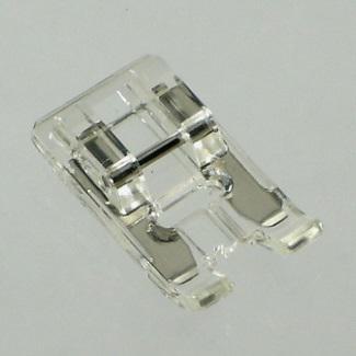 A clear plastic satin stitch sewing machine presser foot attachment.