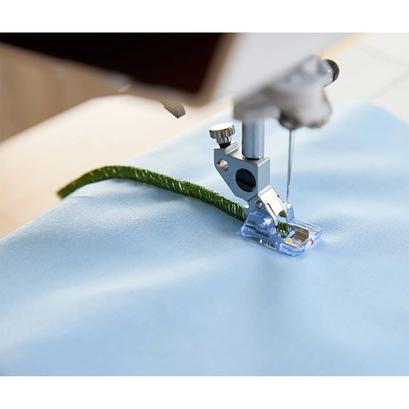A clear stitch-in-the-ditch presser foot with a center guide sewing directly along a seam.